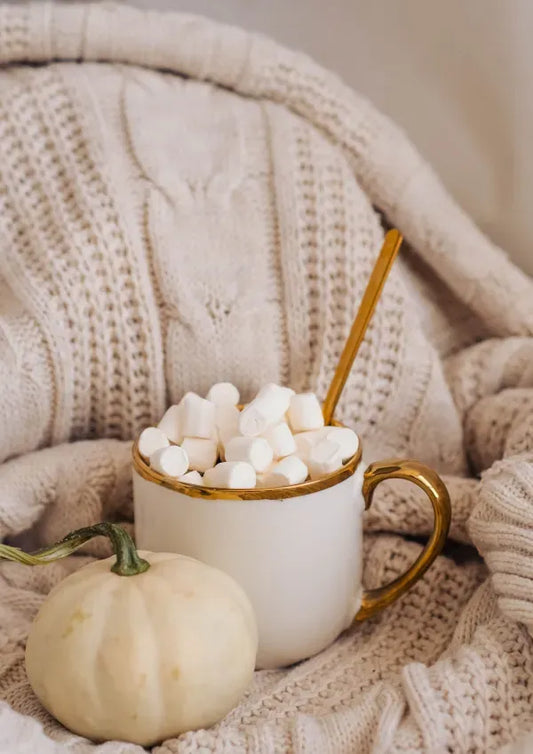 White mug filled with marshmallows, a small pumpkin CM Fashion womens clothing trend